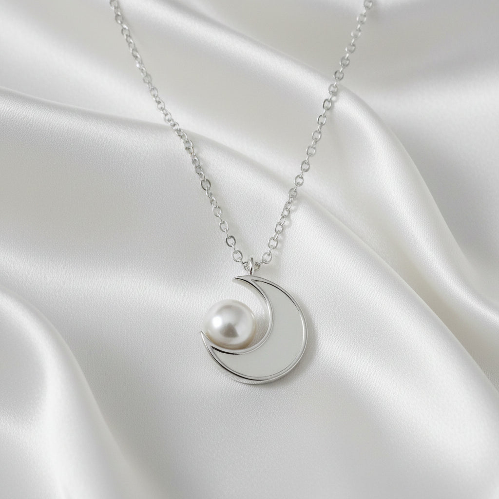 Silver Crescent Moon Pearl Necklace on a satin surface