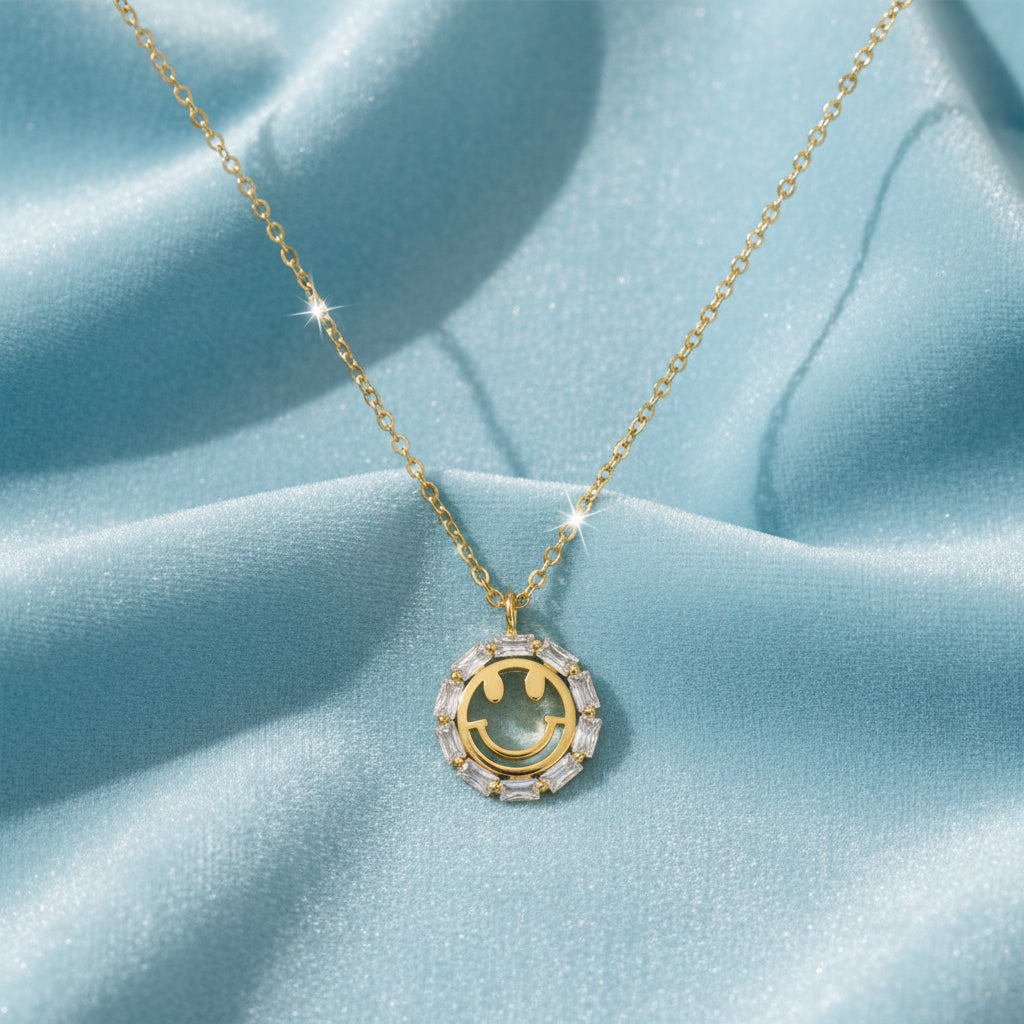 Gold Crystal Smiley Face Necklace on a light blue background