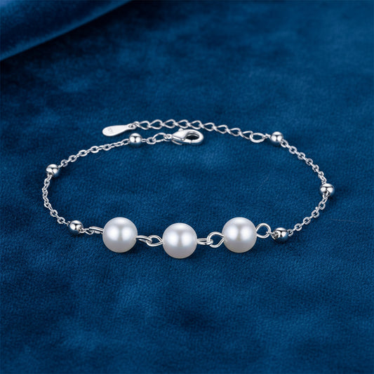 Silver Pearl Bracelet on a blue fabric background